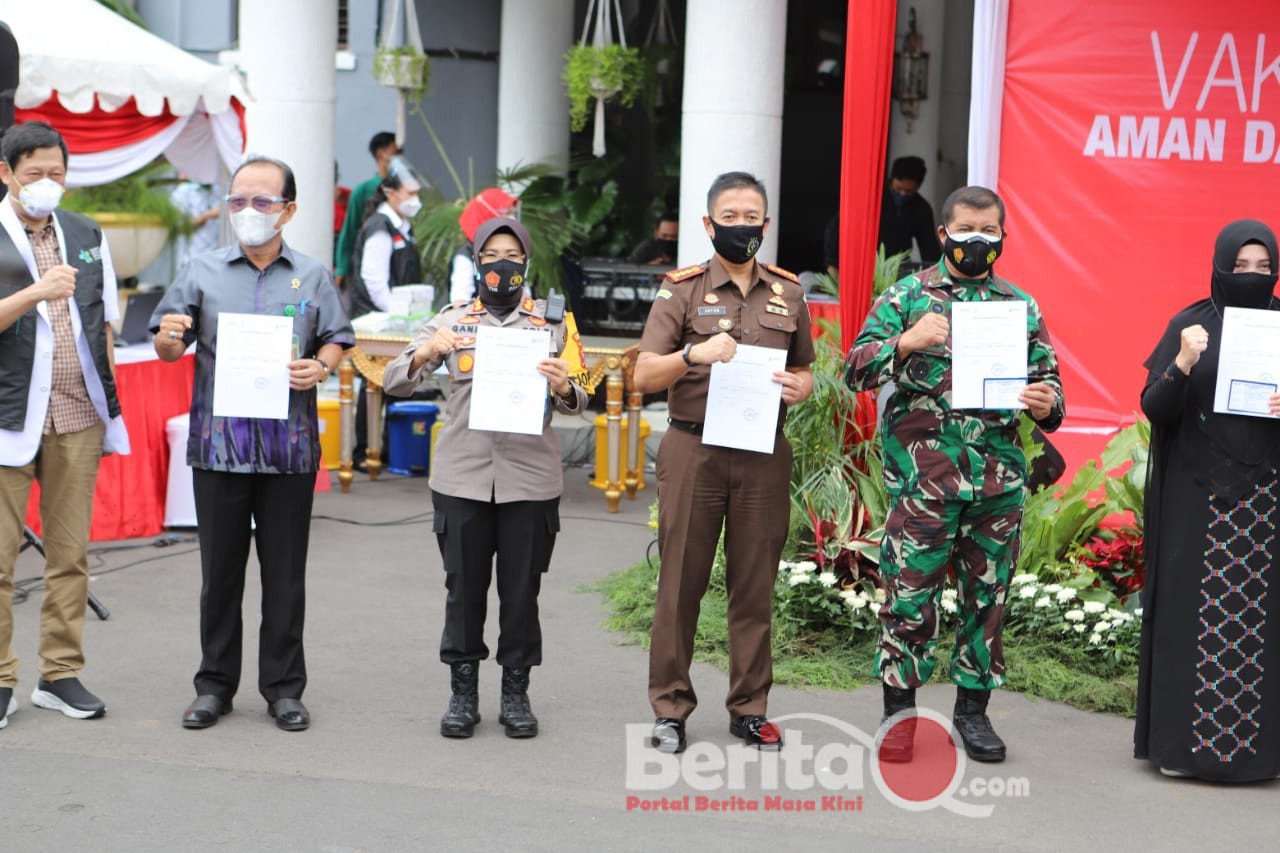 Kapolres Pelabuhan Tanjung Perak dan pejabat lain menunjukkan surat vaksin