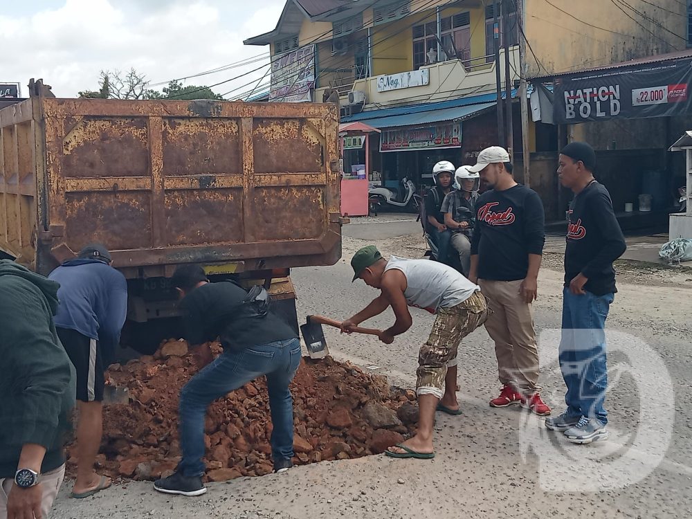 Forum Pemuda Dayak (FOPAD) Kabupaten Melawi secara swadaya dan gotong royong menambal jalan berlobang ruas jalan nasional tepatnya jalan Nanga Pinoh- Kota Baru